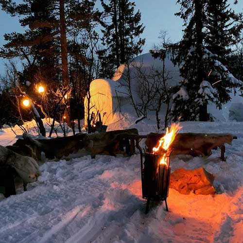 Brasa ute i snön med en igloo i bakgrunden